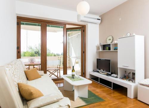 Apartment Penetra في كافتات: غرفة معيشة مع أريكة بيضاء وتلفزيون