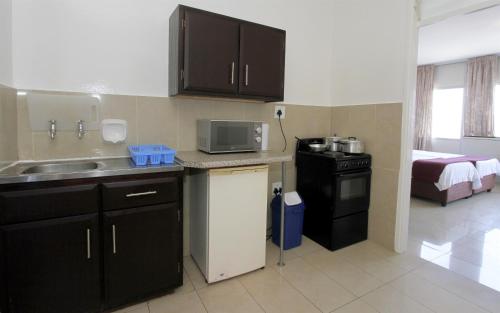 a small kitchen with a sink and a microwave at Coastlands Durban Self Catering Holiday Apartments in Durban