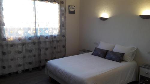 a bedroom with a white bed and a window at Chez Nous in Fitou