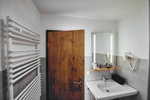 a bathroom with a wooden door and a sink at Die Burg in Donaueschingen