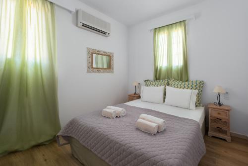 a bedroom with a large bed with two pillows on it at Milos Villas Complex in Pefki Rhodes