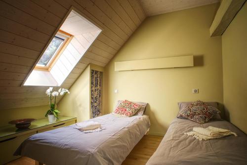 デュアンにあるAngel Services - La Bergerieの屋根裏のベッドルーム(ベッド2台、窓付)