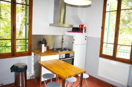 een keuken met een houten tafel en een fornuis bij Angel Services - Le Nant in Saint-Jorioz