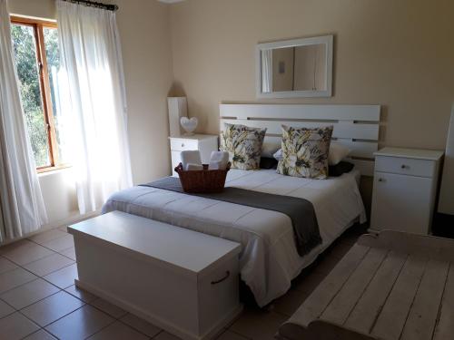 a bedroom with a bed with a basket on it at The Upper Deck Apartment in Swellendam