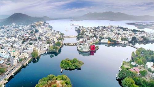 una vista aérea de una ciudad sobre el agua en Oolala - Your lake house in the center of Udaipur en Udaipur