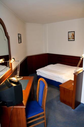 a hotel room with a bed and a desk with a tv at Hotel Garni Italia in Bühl