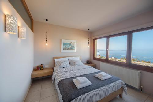a bedroom with a bed with two towels on it at Sody Magnificent Bay View in Chania