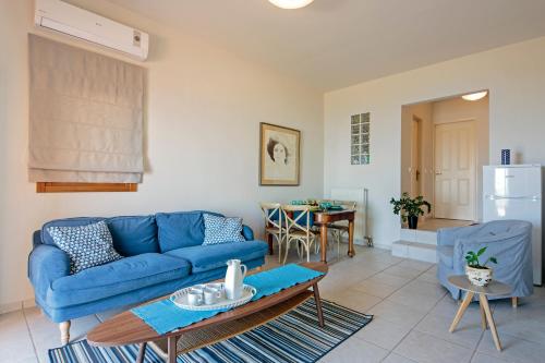 a living room with a blue couch and a table at Sody Magnificent Bay View in Chania