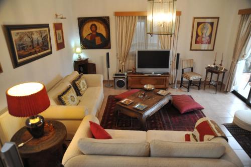 a living room with couches and a flat screen tv at Residence L' Aubrais in Limassol