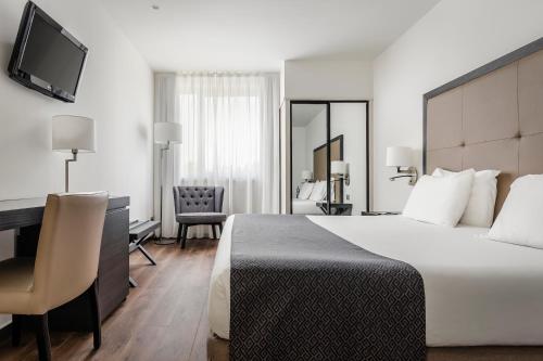 a hotel room with a bed and a desk at Exe Parc del Vallés in Cerdanyola del Valles