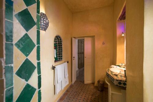 a bathroom with a sink and a mirror at Riad Emotion in Essaouira