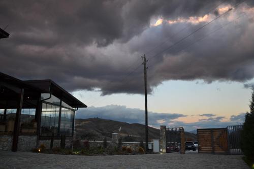 a cloudy sky with a building and a pole at Ciflik Winery in Bitola