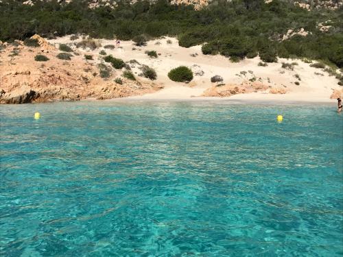 a body of water with a beach in the background at Hotel Villa Del Parco in La Maddalena