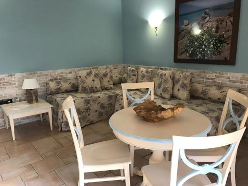 a living room with a table and chairs and a couch at Hotel Villa Del Parco in La Maddalena