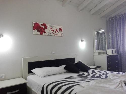 a bedroom with a bed with a black and white blanket at Vip Apartment by "Murati" in Ksamil