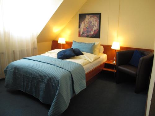 a hotel room with a bed and a chair at Burghotel Münzenberg in Münzenberg