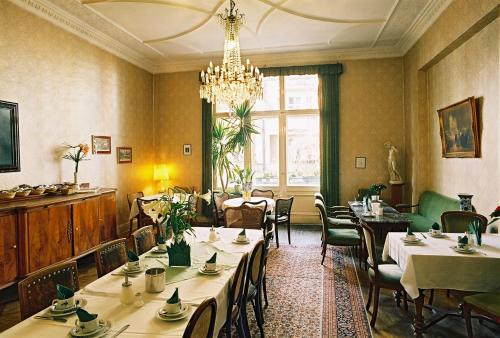 a restaurant with tables and chairs and a chandelier at Hotel-Pension Funk am Kurfürstendamm in Berlin