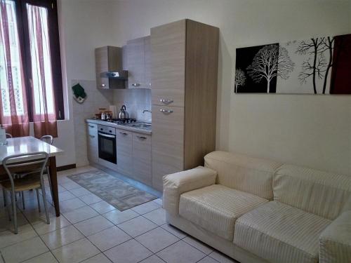 een woonkamer met een bank en een keuken bij Casa Nax in Terni