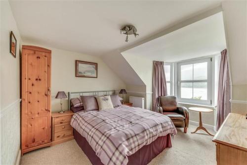 a bedroom with a bed and a chair and a window at TwoStones in Arrochar