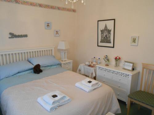 a bedroom with two beds with towels and a dresser at Rose Villa Bed and Breakfast in Forfar