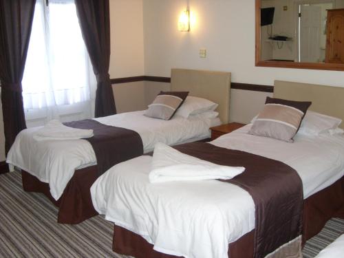 Phoenix Hotel في شارد: غرفة فندقية بسريرين ومرآة
