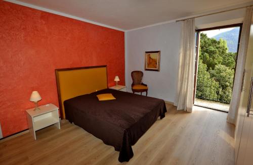 ein Schlafzimmer mit einem Bett und einem großen Fenster in der Unterkunft Appartamento Castello in Cannobio