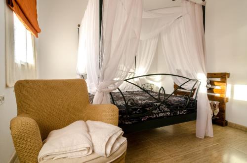 1 dormitorio con 1 cama y 1 silla con dosel en CASA ENCANTADORA VTAR/SE/180, en Pilas