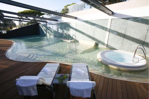 a swimming pool with a tub in a building at Modern 2 Bed Apartment Vale do Lobo in Vale do Lobo