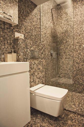 a bathroom with a toilet and a glass shower at Baltic Beach Retreat in Nida