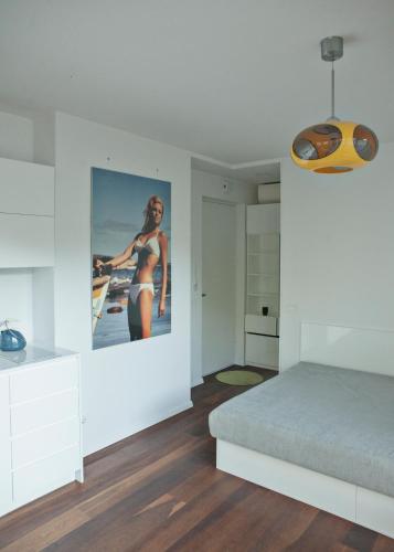 a white bedroom with a poster of a woman on the wall at Baltic Beach Retreat in Nida