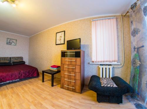オムスクにあるRENT-сервис Apartment Serovaのベッドルーム(ベッド1台、テレビ、椅子付)