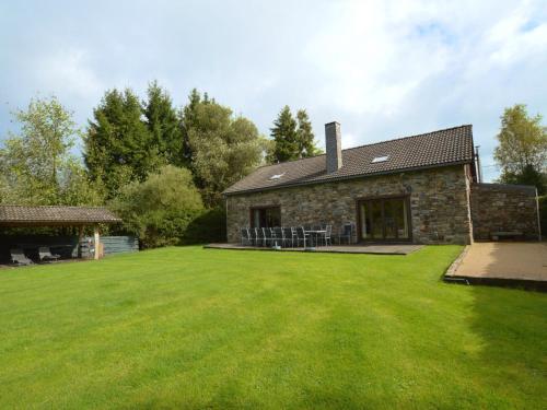 a stone house with a large lawn in front of it at Beautiful Holiday Home in Beverc with Sauna in Malmedy