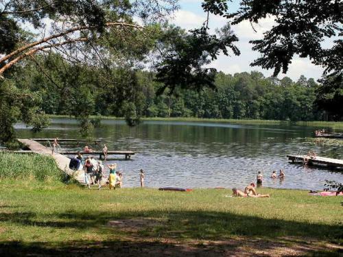 a group of people on the shore of a lake at domek nad jeziorem in Kujan