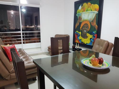 a table with a plate of fruit and a painting at Palmagua in Barranquilla