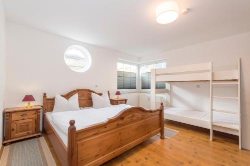Schlafzimmer mit einem Holzbett und Etagenbetten in der Unterkunft Villa Mona Lisa Whg. 6 in Göhren