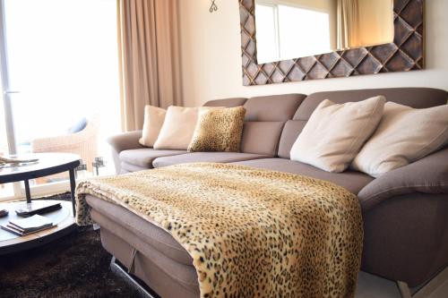 a living room with a couch with a leopard blanket on it at La Concha Vista La Quinta in Marbella