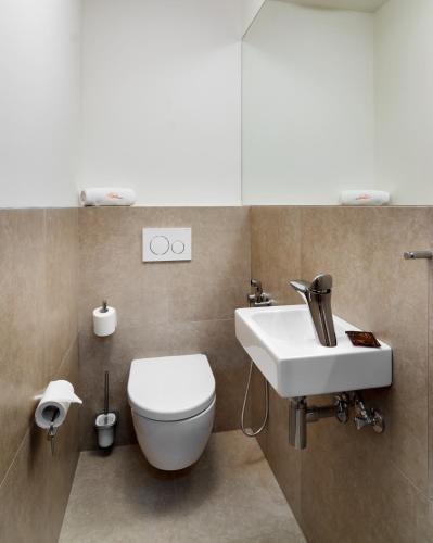 a bathroom with a toilet and a sink at Aparthotel Residence Grand Špindlerův Mlýn in Špindlerův Mlýn