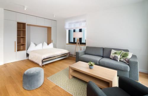 - un salon avec un canapé et un lit dans l'établissement Apartments Residence Grand, à Špindlerův Mlýn