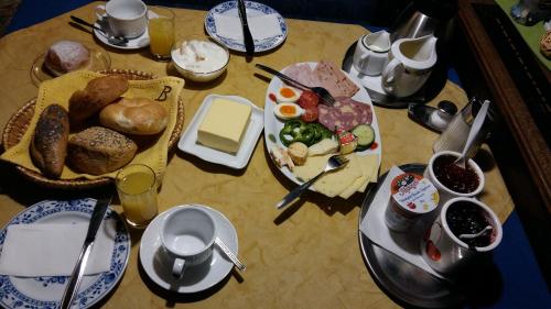 a table topped with plates of food and eggs at Hotel/Pension Rosengarten in Franking