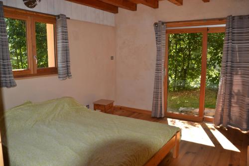 a bedroom with a bed and two windows at Les Ondines in Gembrie