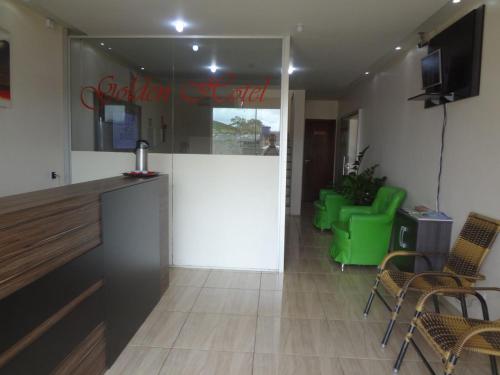 a waiting room with green chairs and a counter at Golden Hotel in Vilhena