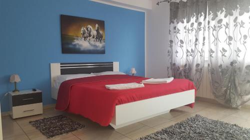 テキルギオルにあるPensiunea Leonteの青い壁のベッドルーム1室(赤いベッド1台付)