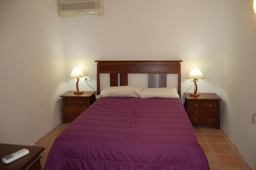 ベグールにあるbegurhomeのベッドルーム1室(紫色のベッド1台、ナイトスタンド2台付)