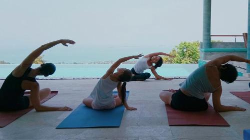 a group of people doing yoga by the water at Villa Bella in Bophut 