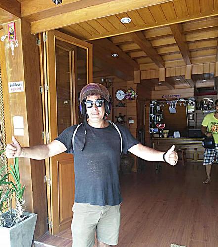 a man wearing headphones standing in a room with his arms out at Baan Ratchapruek in Phuket Town