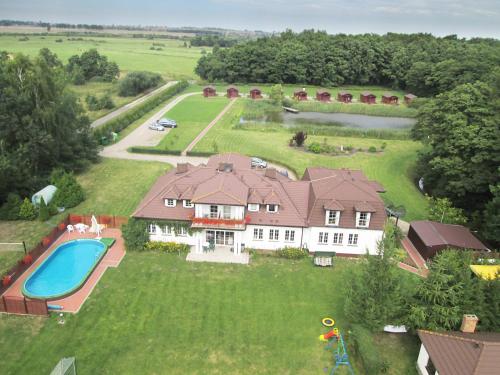 an aerial view of a large house with a swimming pool at Leśny Dworek Winnica Darłowo in Darłowo