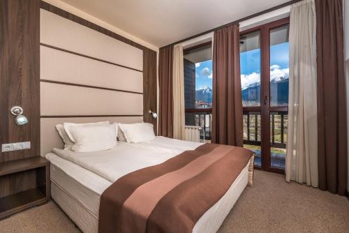 a bedroom with a bed with a large window at Hotel Zara in Bansko