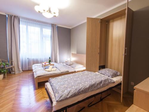 プラハにあるModern Central Apartment Dlouháのベッドルーム1室(ベッド2台、大きな窓付)