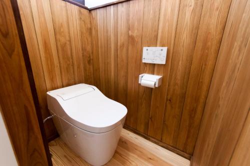 a bathroom with a toilet in a wooden wall at Suikomareso in Hita