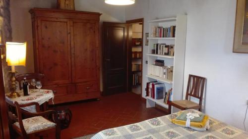カステッリーナ・イン・キアンティにあるColle Petrosoのテーブルと椅子、本棚が備わる部屋